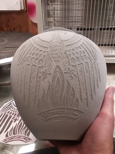 carving a Phoenix in clay to create a memorial urn
